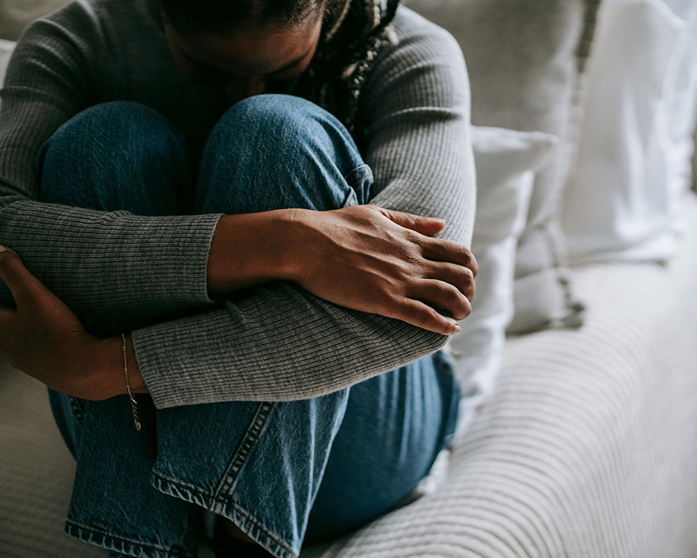 woman holding head in knees at grief counseling