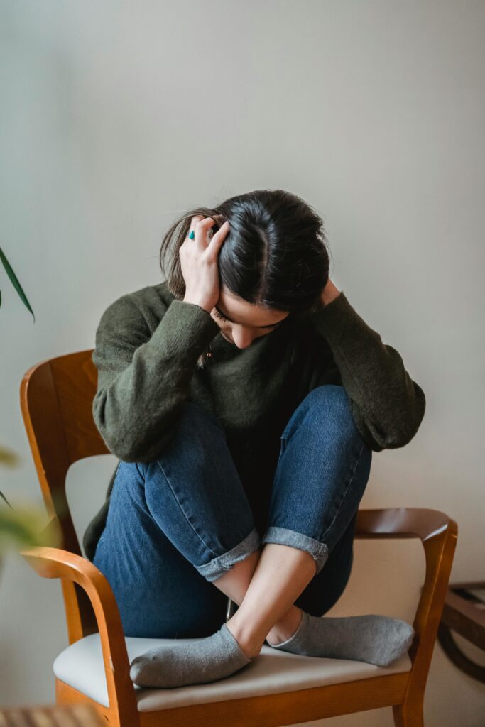 woman with head in hands worrying