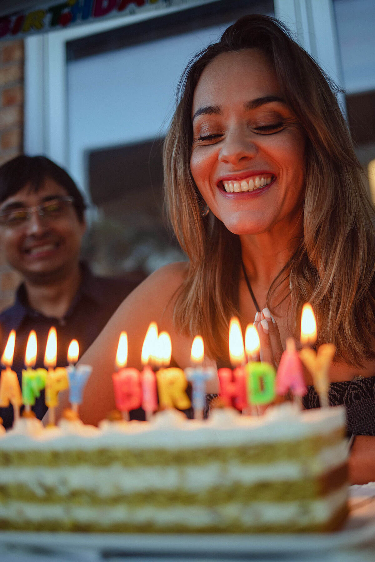 Woman blowing out birthday candles after dealing with birthday blues