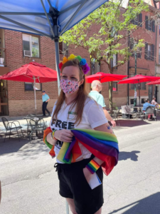 The author attending a pride event wrapped in a rainbow flag.