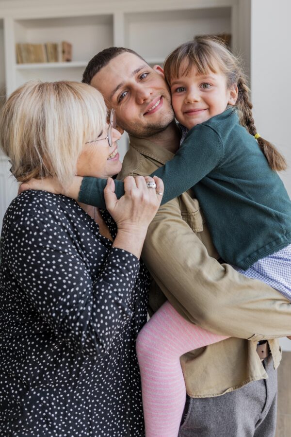 portrait of man, woman, and girl hugging