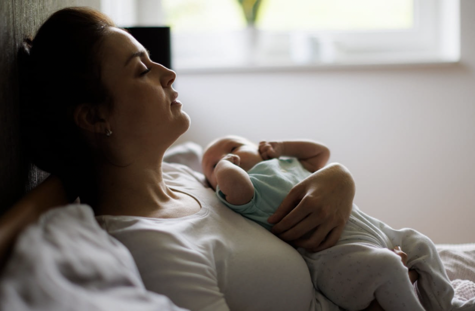 photo of a woman holding her baby with postpartum anxiety