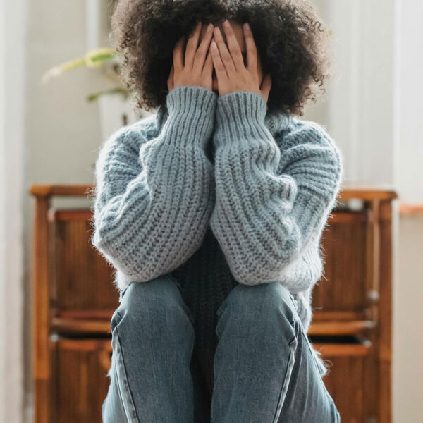 woman with hands covering face for post about grief