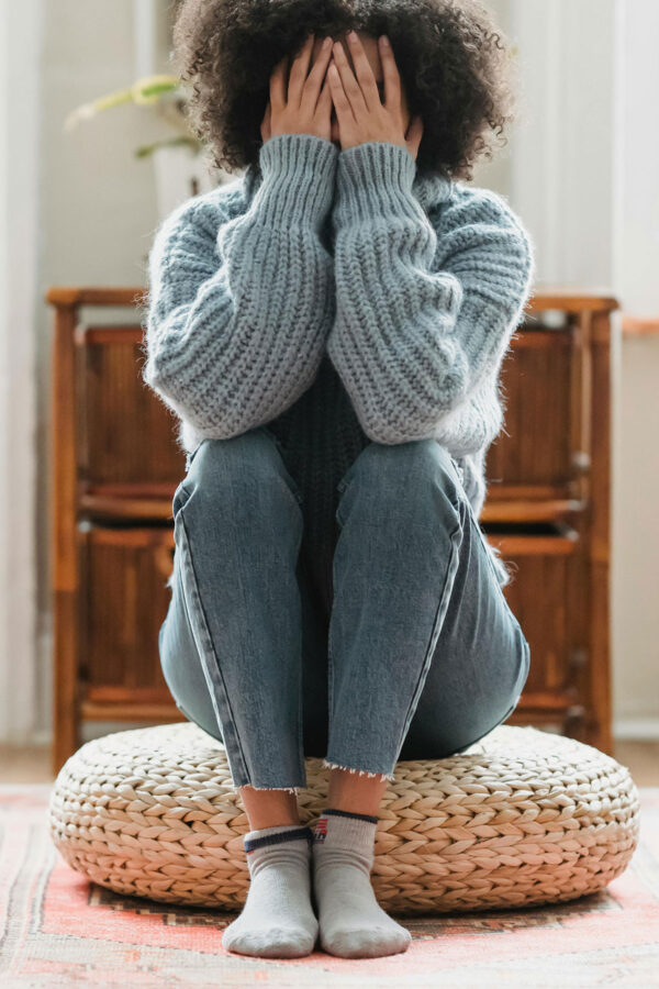 woman with hands covering face for post about grief