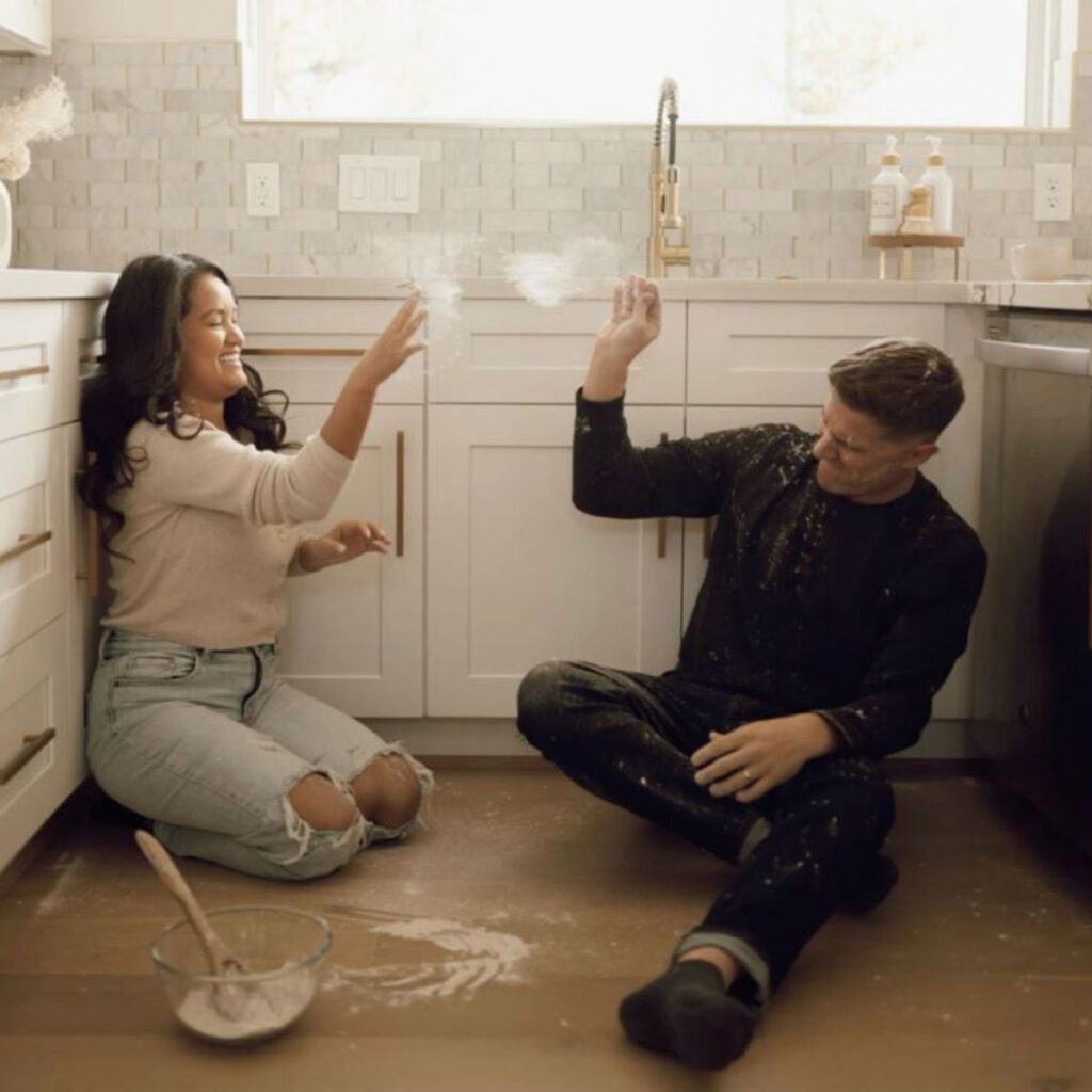 A couple fighting sitting on a kitchen floor