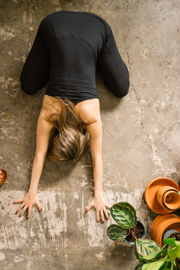 woman in black stretching on floor