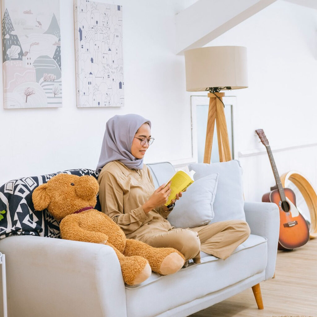 A woman reading by engaging in self care and taking care of her future self