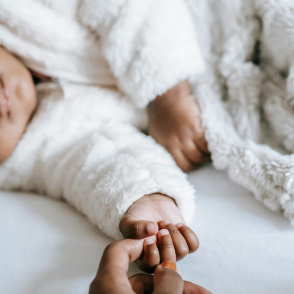 image of mothers hand holding childs hand for article on postpartum anxiety