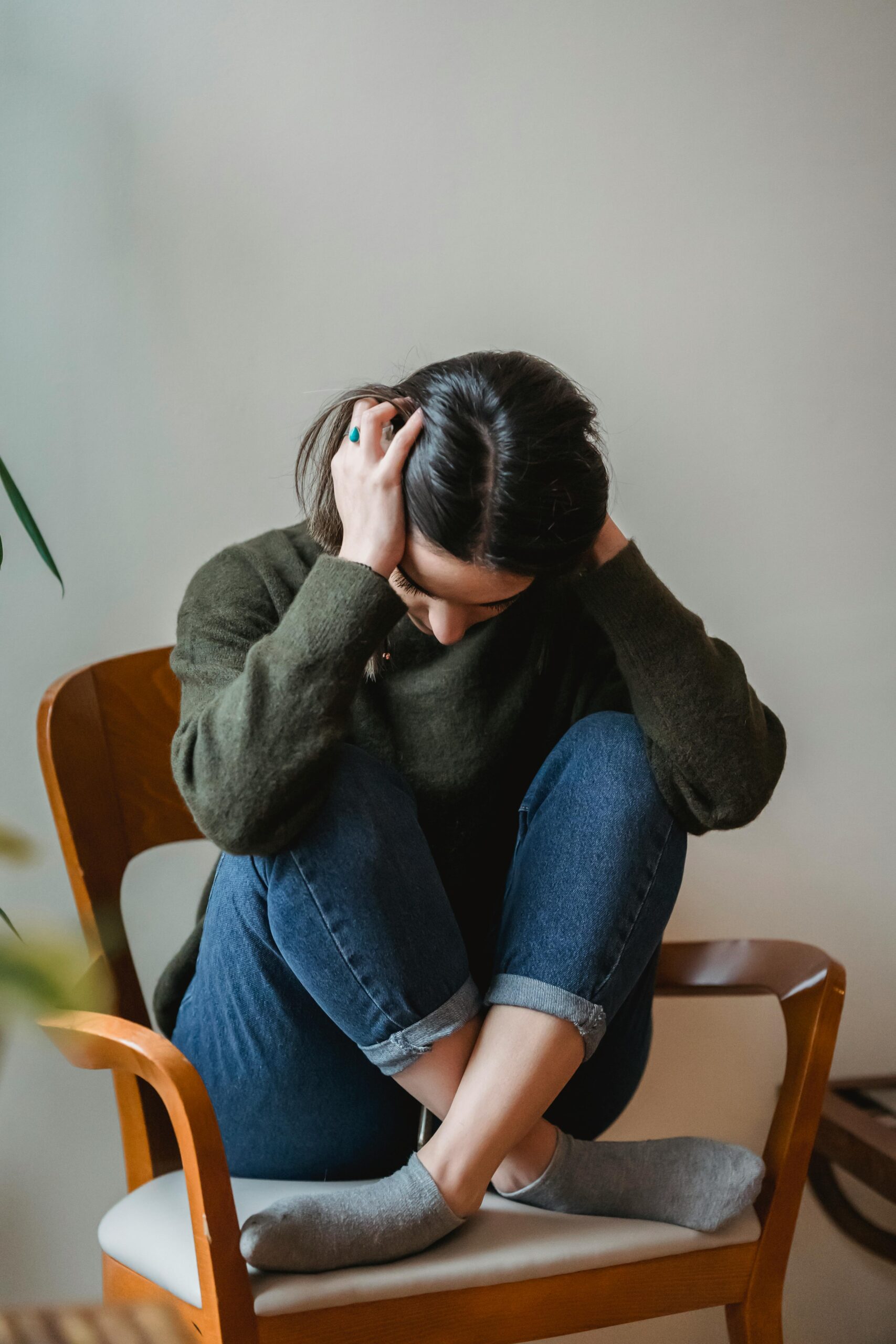 woman with head in hands experiencing  link between hormones and anxiety