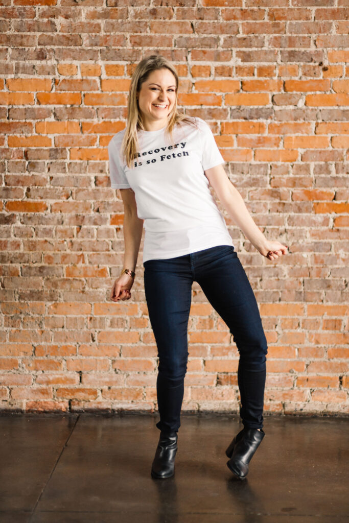 photo of Amanda E. White wearing a shirt that says "recovery is so fetch". 