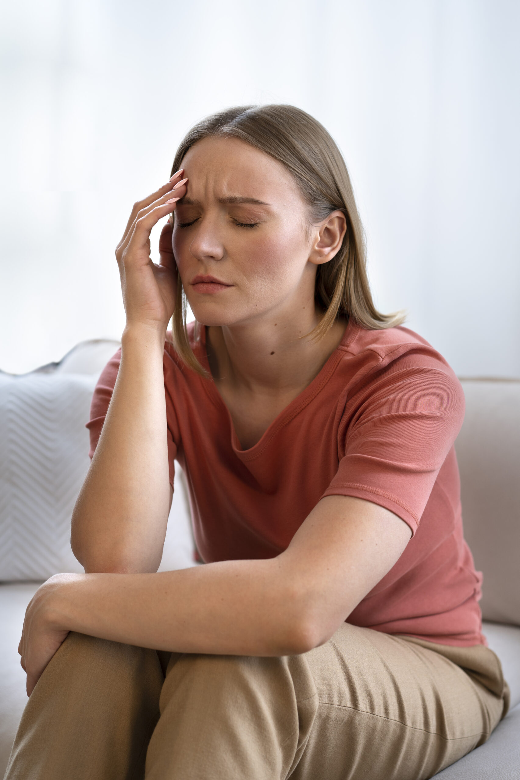 Woman struggling with OCD sitting on a couch