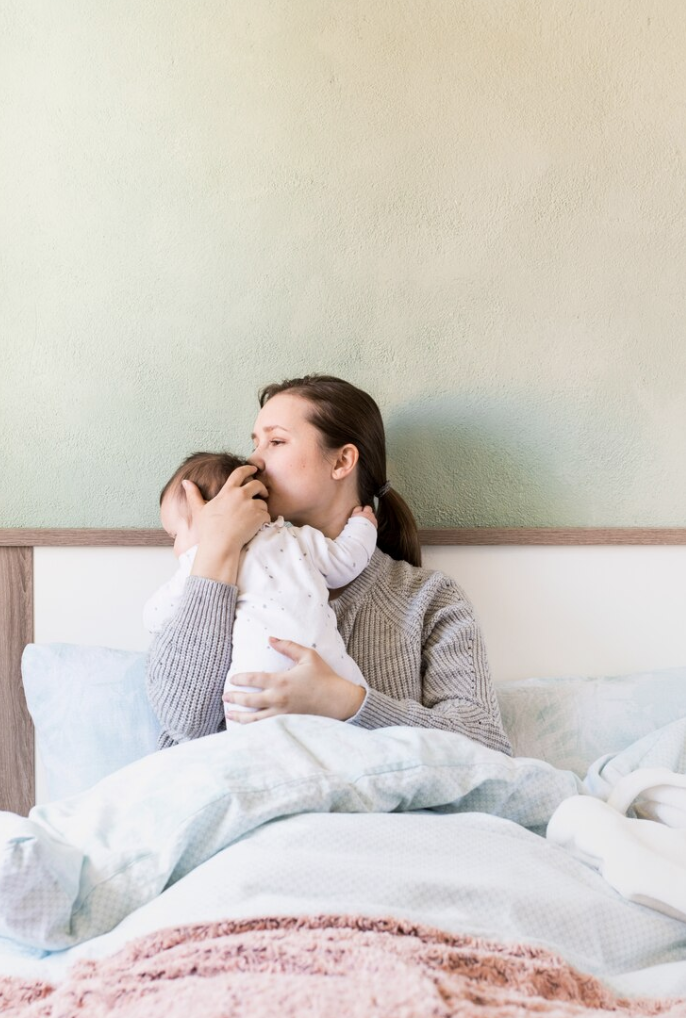 new mother holding her infant struggling with postpartum anxiety