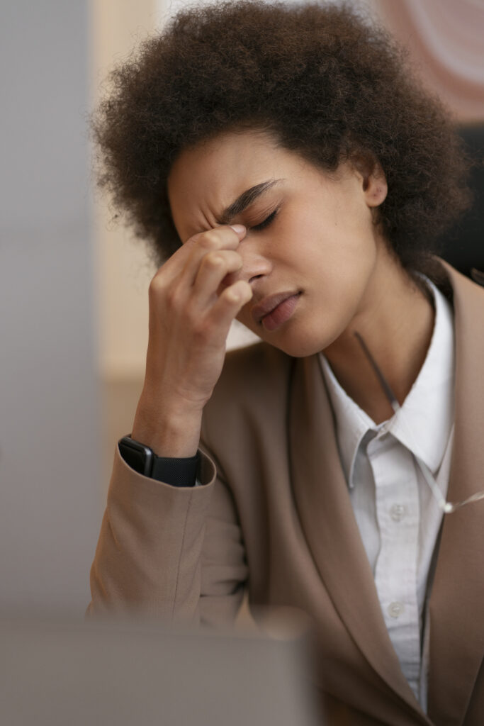 mixed race woman putting hands between her eyes struggling with quarter-life crisis