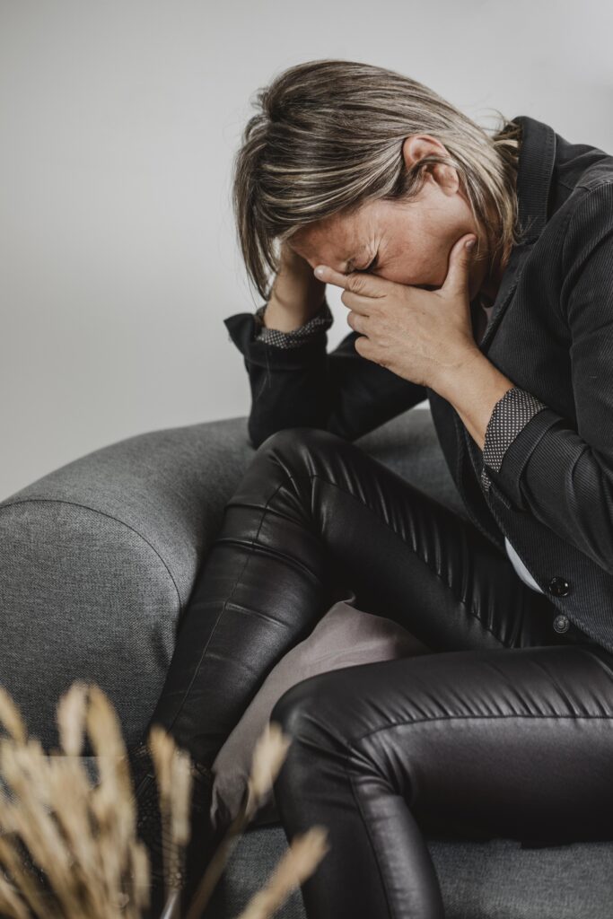 woman crying with grief on the couch
