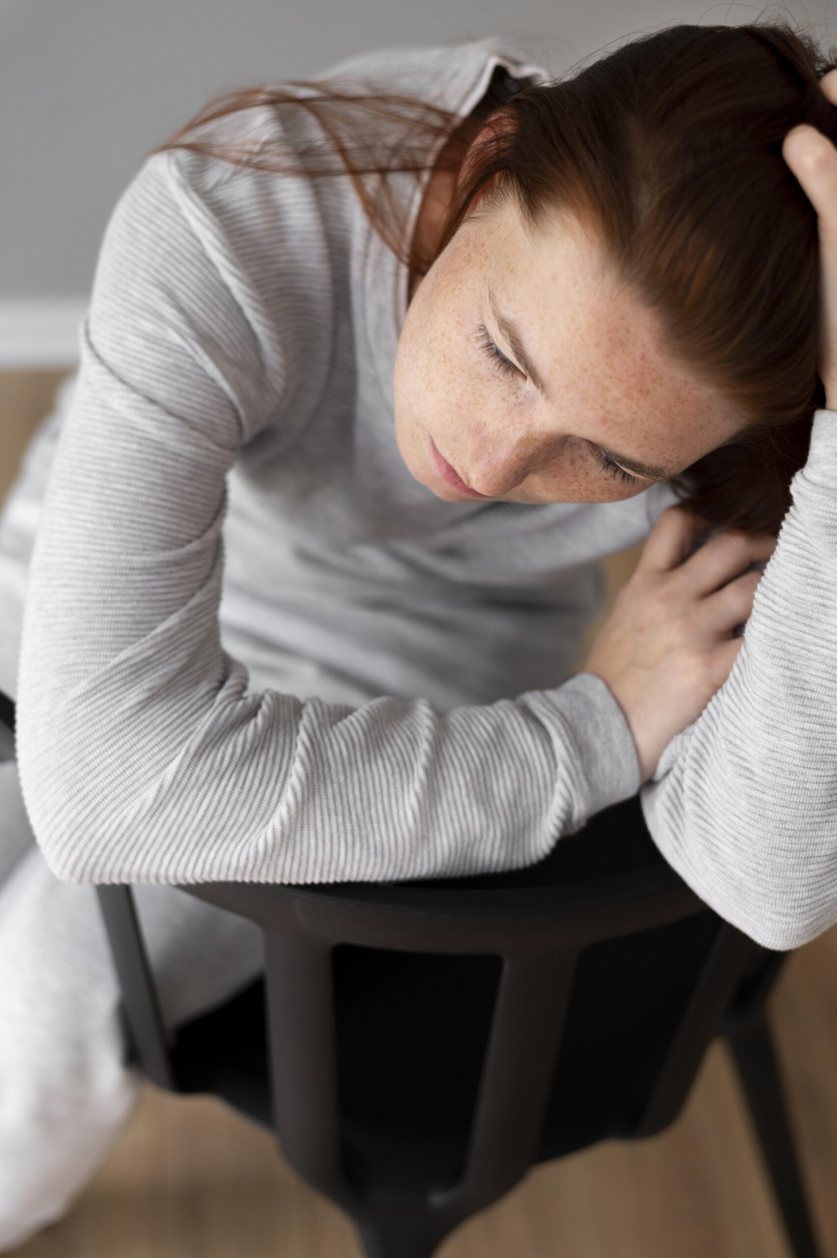 woman hunched over struggling with complex PTSD