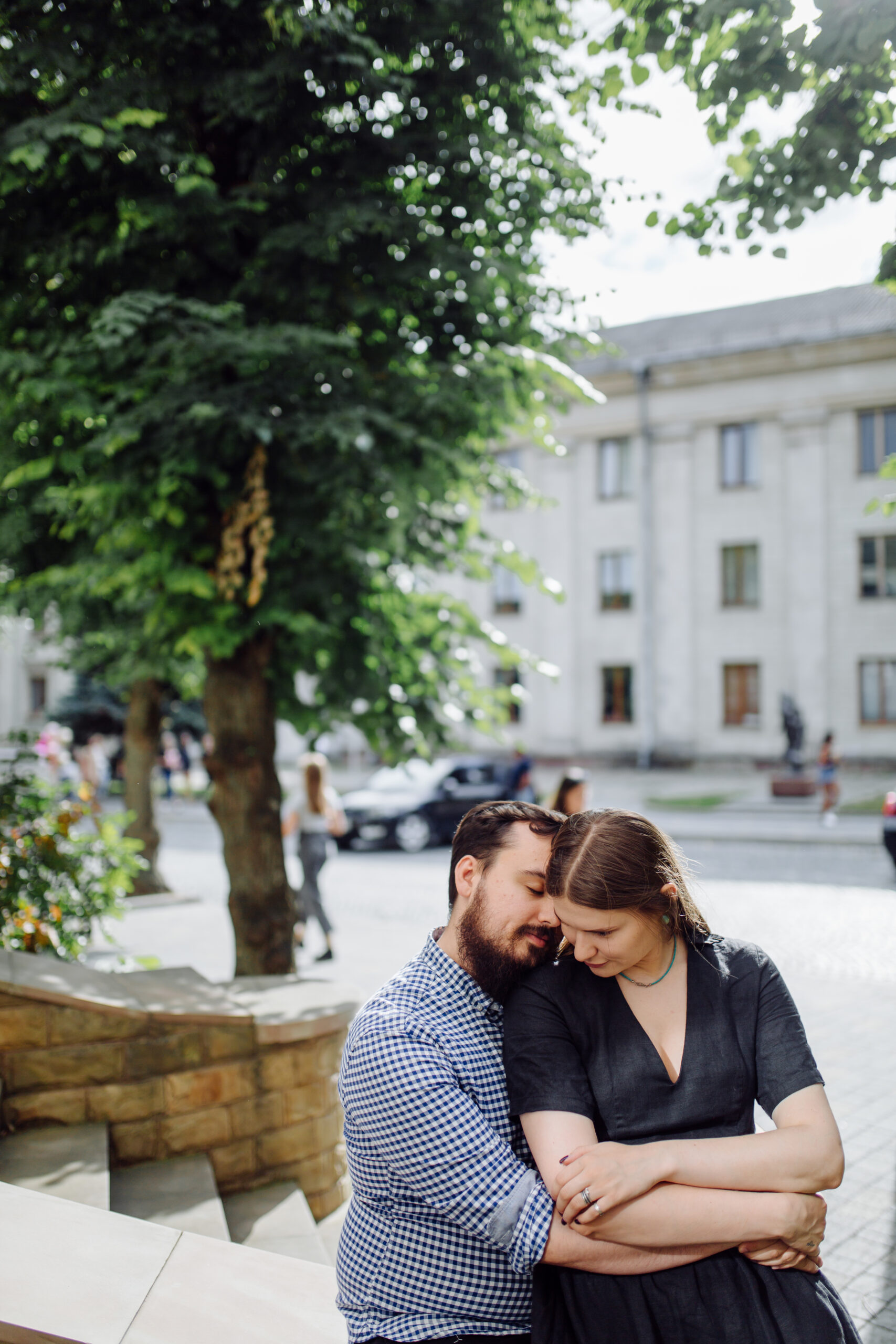 Man and woman hugging outside near a tree. Woman is struggling with reltationship anxiety and feels insecure.