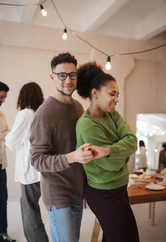 Two estranged adult children dancing at a party