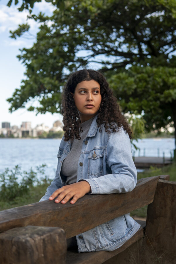 woman sitting on bench in park looking contemplative