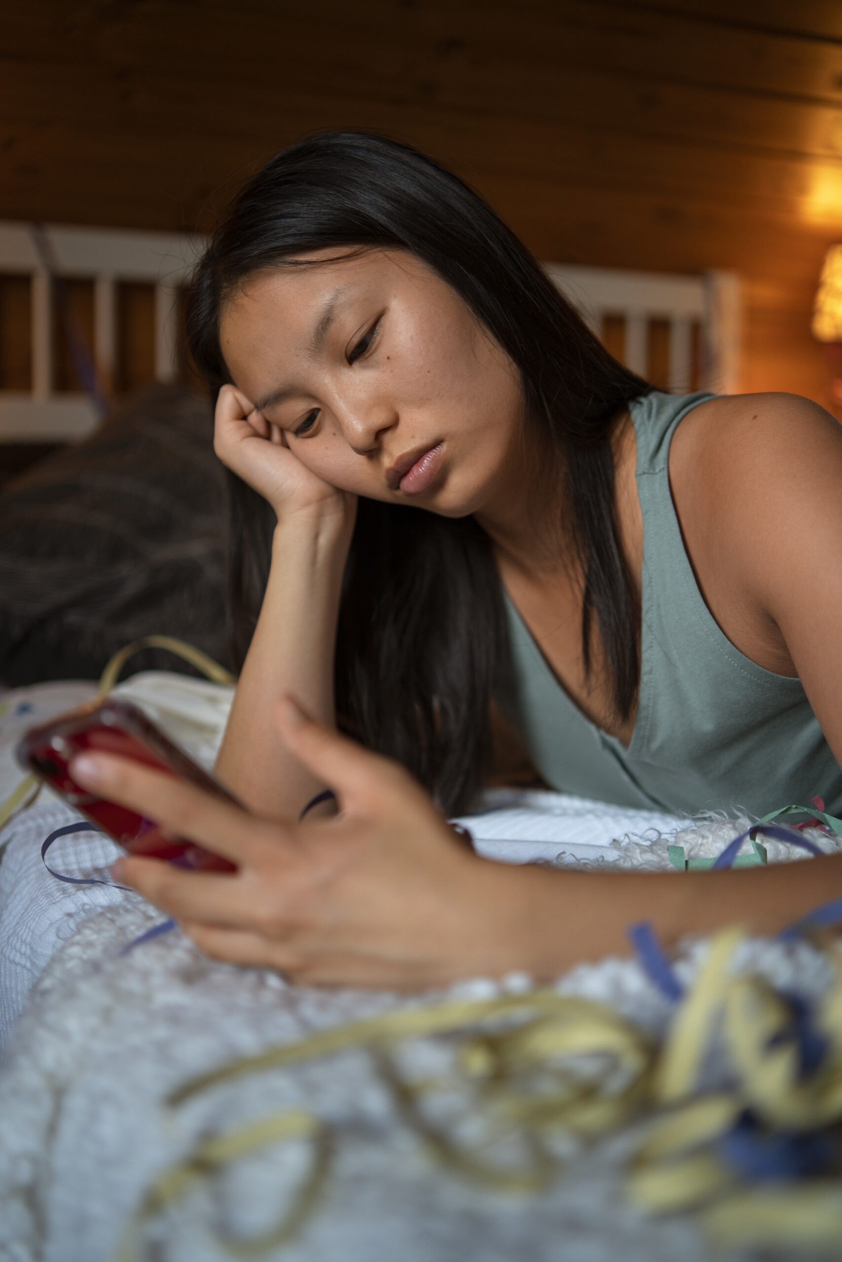 Asian woman googling "how to cut back on drinking" after having another hangover