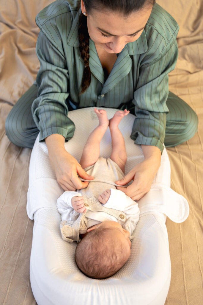 New mom dressing her baby struggling with baby blues 