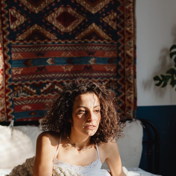 woman in bed looking out of it struggling with perimenopause anxiety