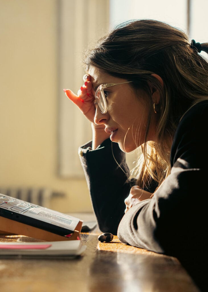 Woman sitting at desk struggling with OCD and intrusive thoughts